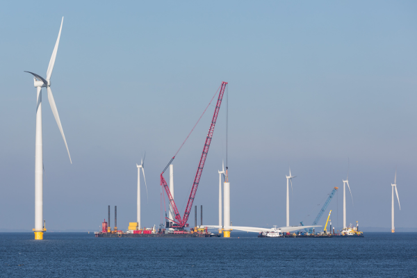 An offshore wind farm under construction with several wind turbines and cranes visible over the water is showcased in the SACS Brochure, which you can conveniently download for more detailed information.