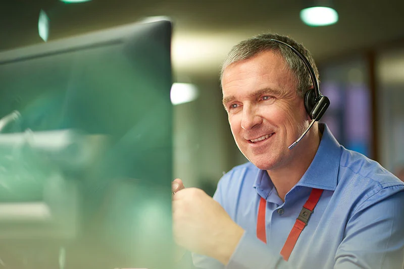 A man wearing a headset in front of a computer, working on creating stronger dikes.